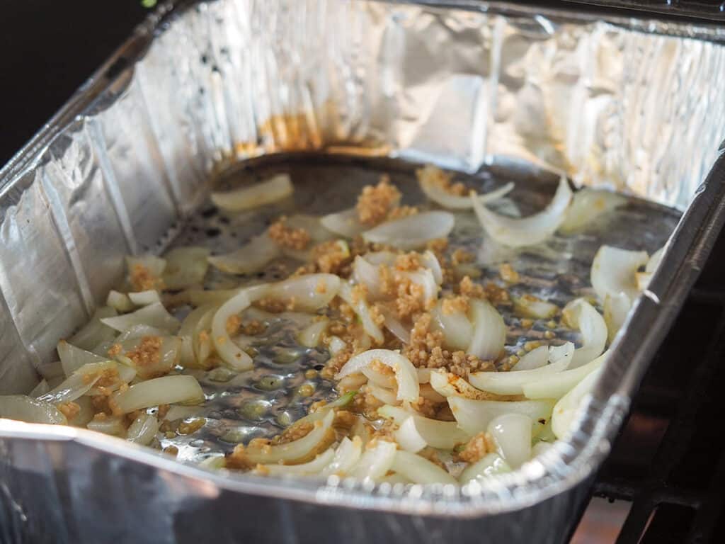 onions and garlic in aluminum pan