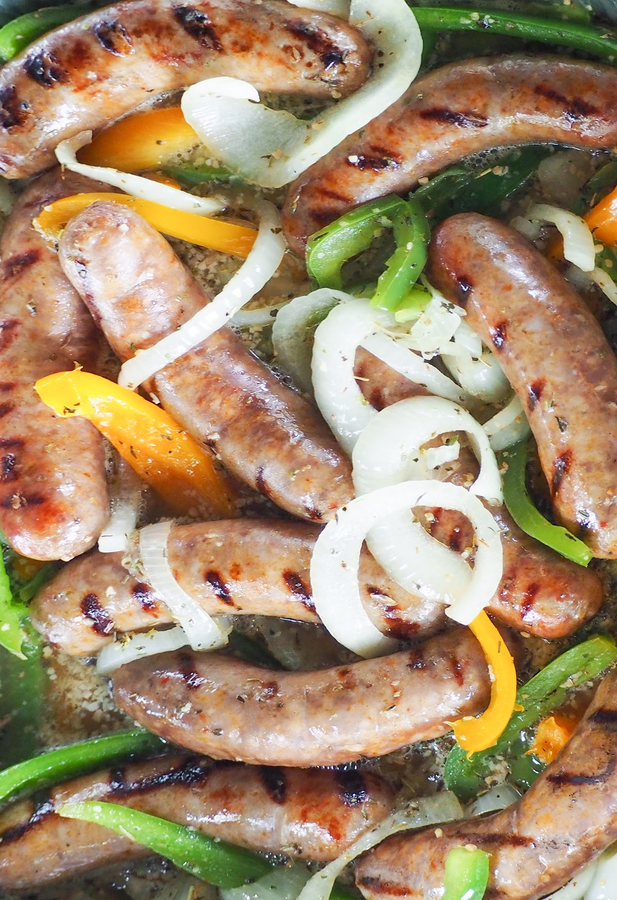 Italian sausages with green peppers and onions braising in beer