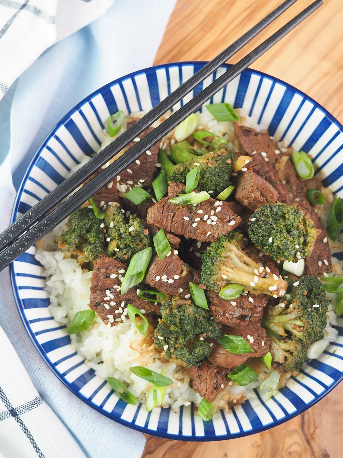 beef and broccoli in bowl with chopsticks