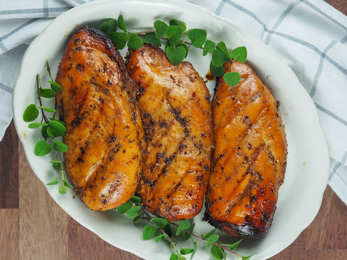 grilled chicken on plate with fresh oregano