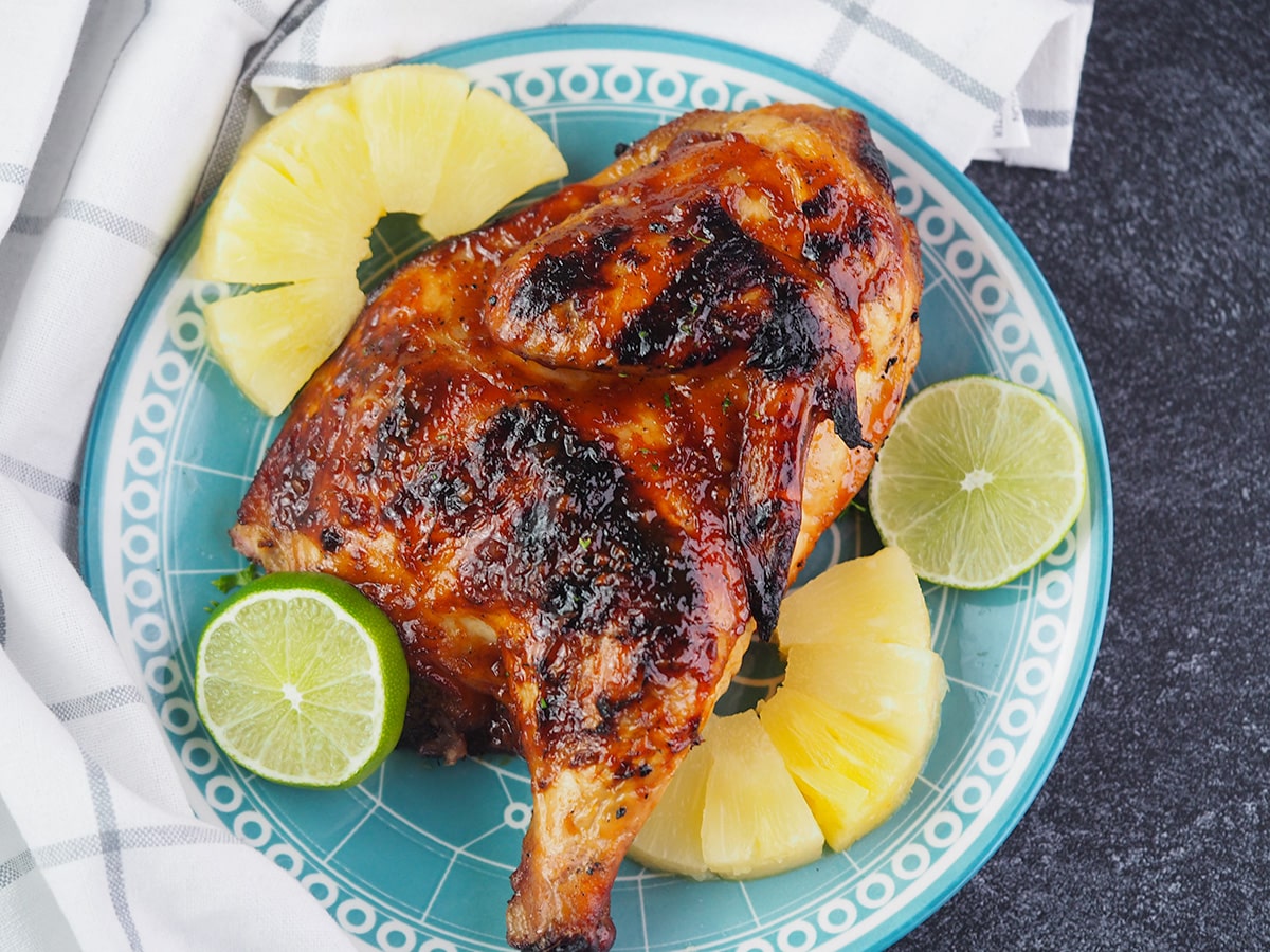 bbq half chicken on plate next to linen towel