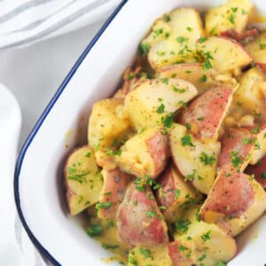 mustard potato salad in serving dish topped with parsley