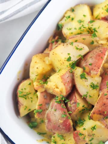 mustard potato salad in serving dish topped with parsley