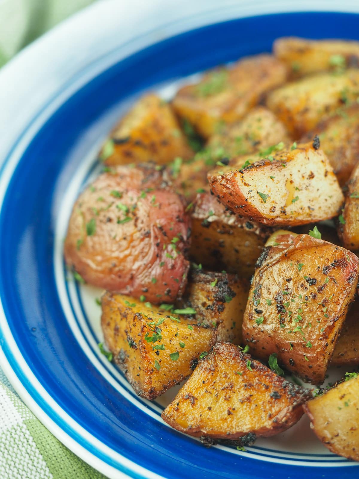 roasted cut potatoes on blue rimmed plate