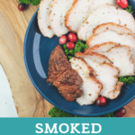 Sliced smoked turkey on blue plate next to gravy boat.